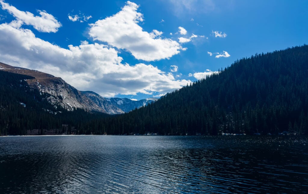 idaho springs reservoir with trees and tall mountains in the background