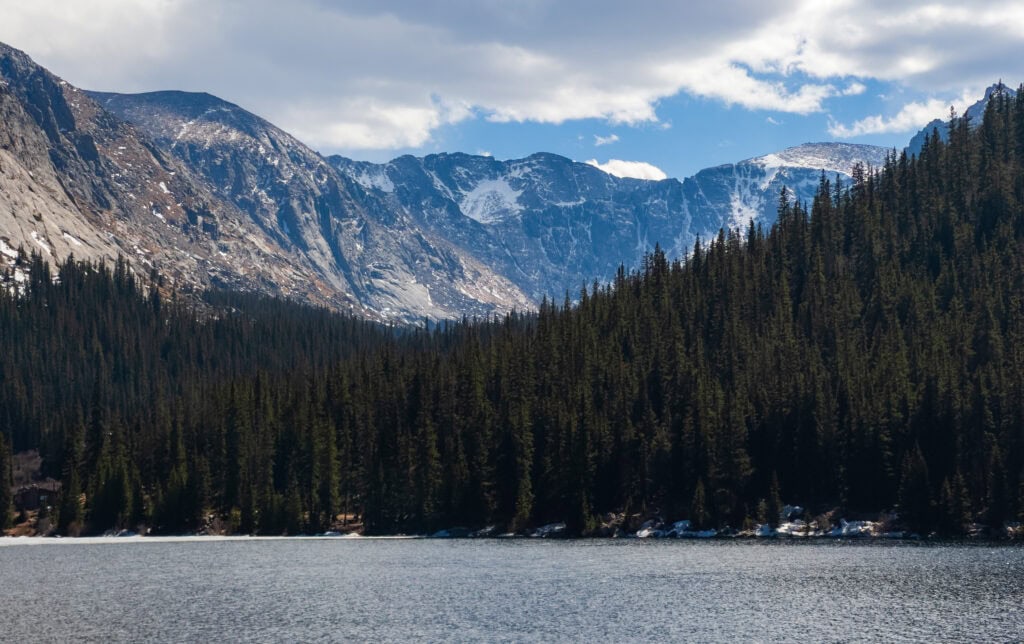 idaho springs reservoir with trees and tall mountains in the background