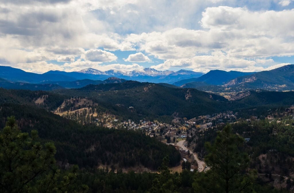 mountains and green trees with clouds above