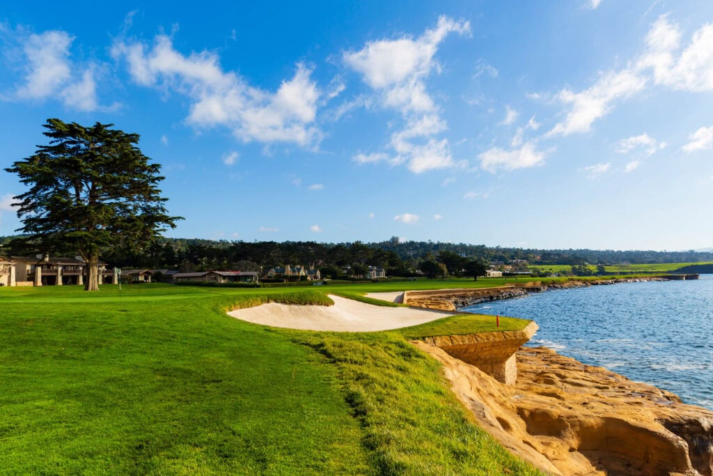 Expansive green fairways of Pebble Beach Golf Links with Stillwater Cove beyond
