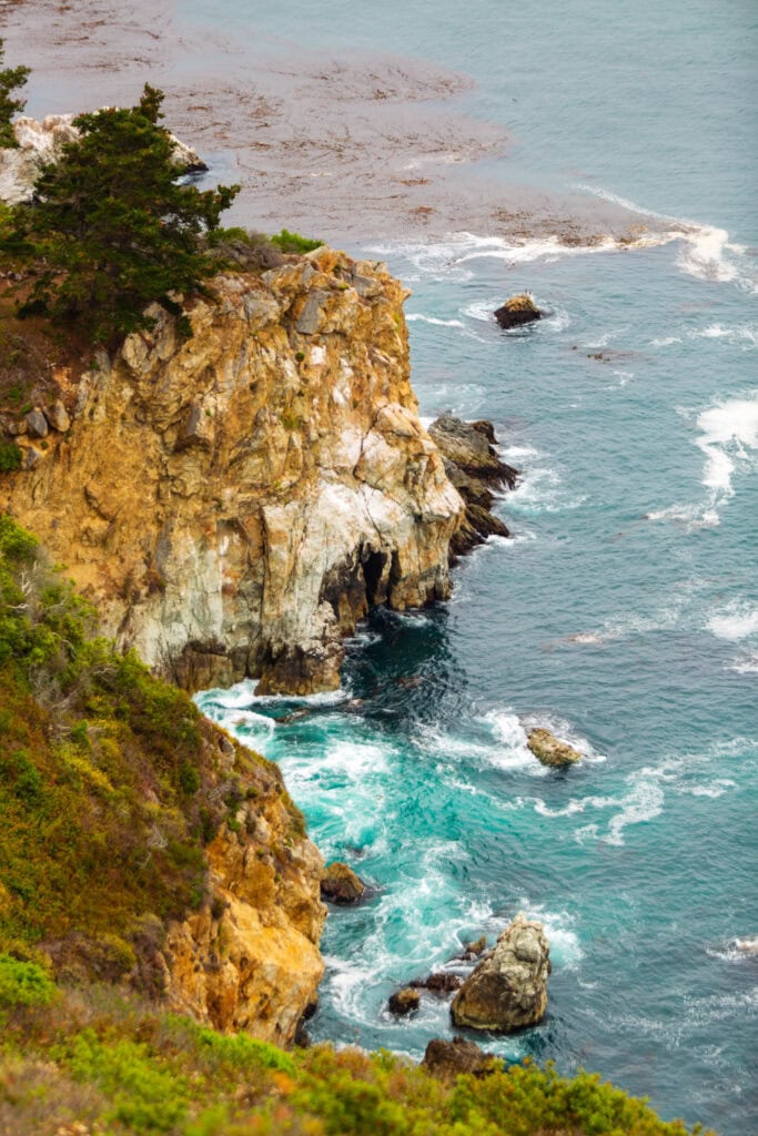 Sea stack rising from turquoise water near a rocky cove at Point Lobos