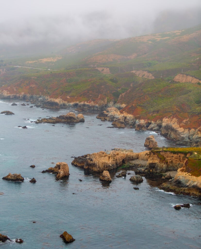 Overcast Big Sur coastline with mist-shrouded sea stacks
