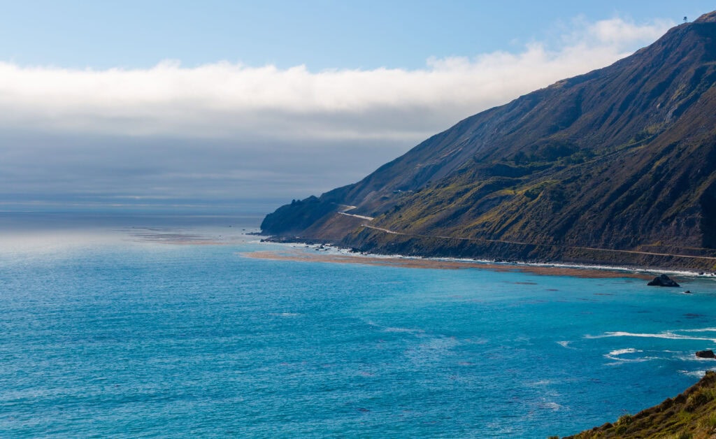 Rocky coastline with golden cliffs dropping into a calm blue-green sea