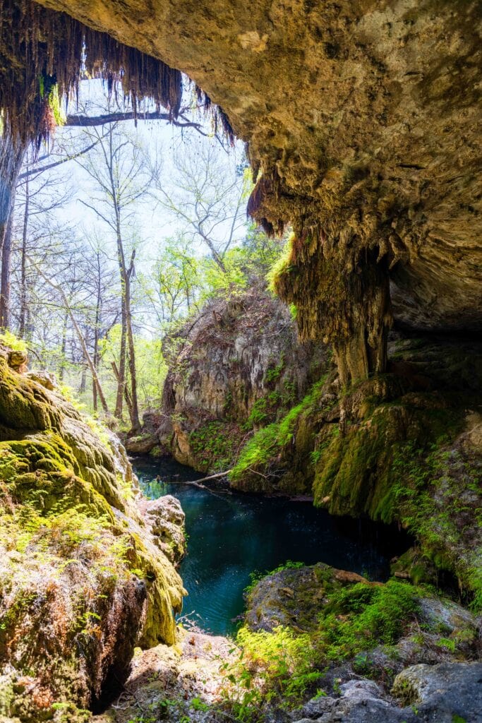 the grotto at west cave discovery center with water below and the overhang of a cave above