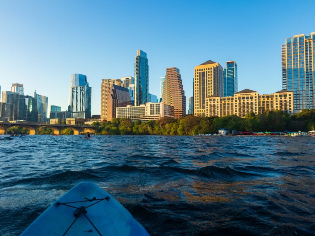 the austin texas skyline viewed from lady bird lake in a kayak