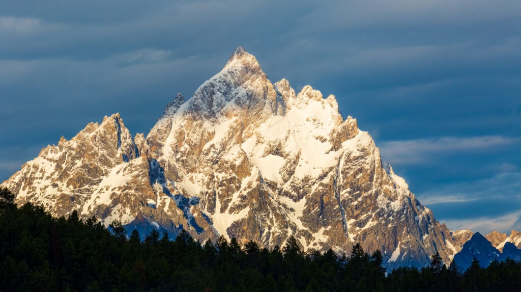 Snow-covered Grand Teton summit photographed in golden winter light