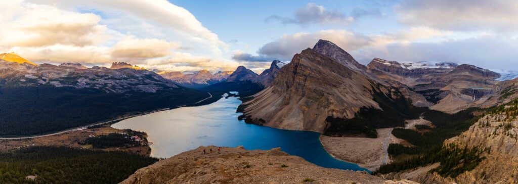 wide panorama of a lake and mountains and clouds