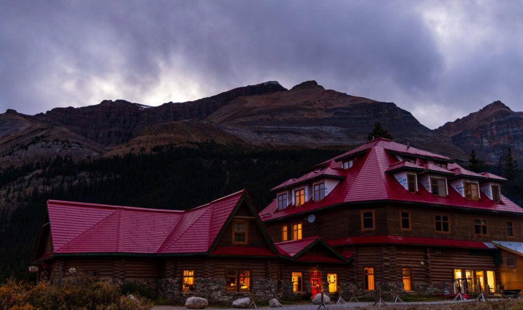 a red building with lights on with a tall mountain above