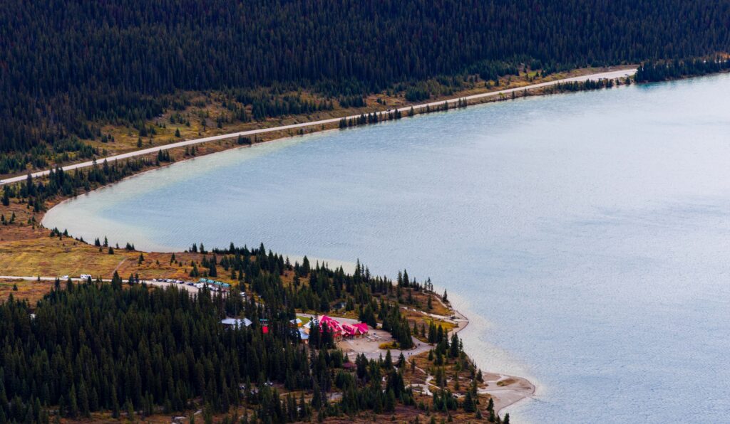 the bow lake lodge with trees surrounding it on the edge of bow lake