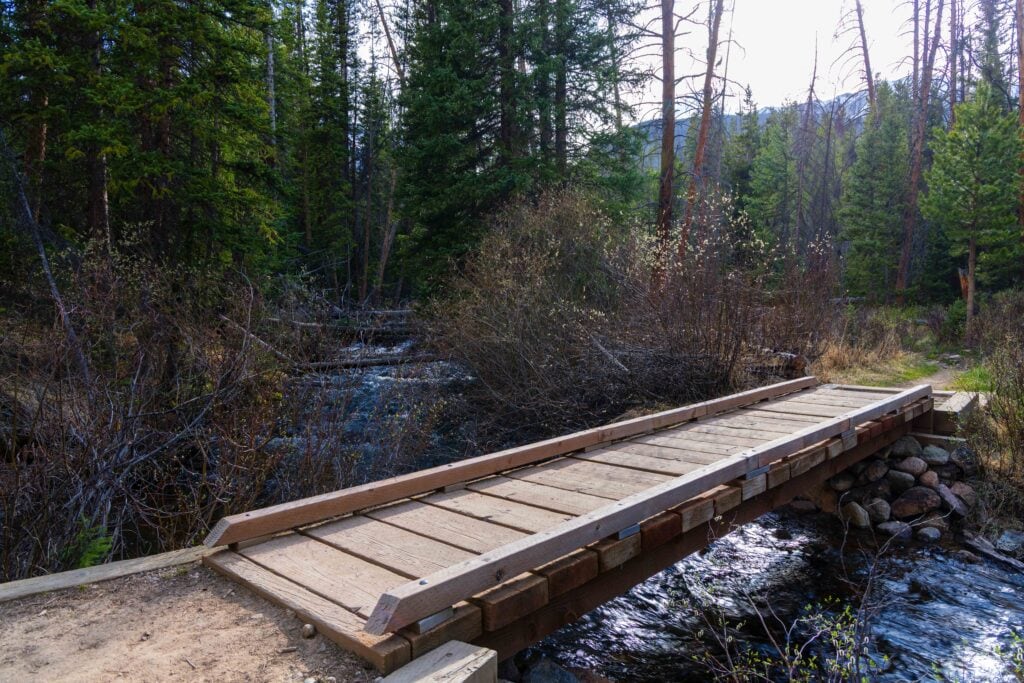 a bridge over a creek in a colorado forest