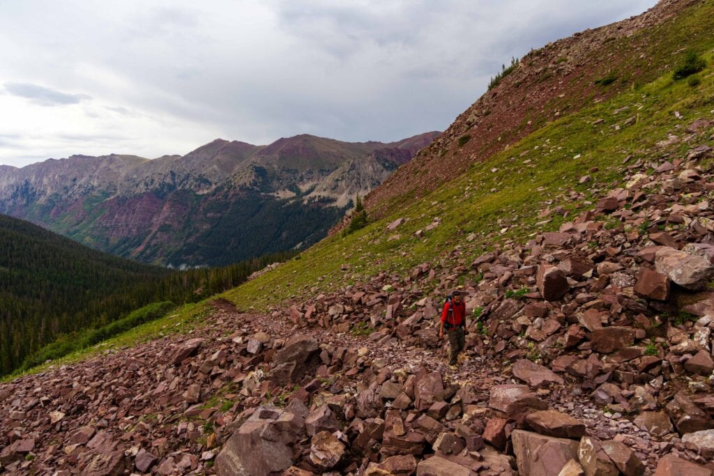 a hiker on the trail in the maroon bells on the four pass loop