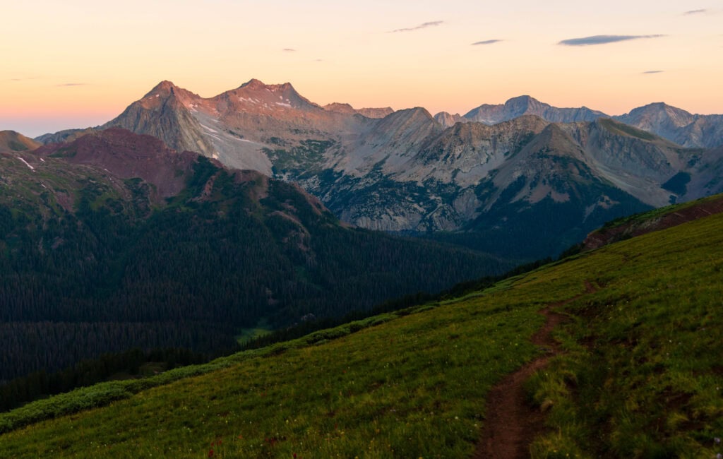 sunrise in colorado illuminating the tops of the mountains