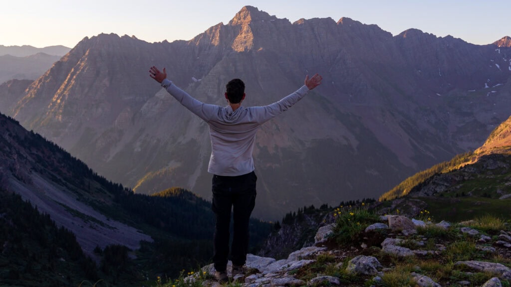 a hiker holds out his hands at buckskin pass in colorado