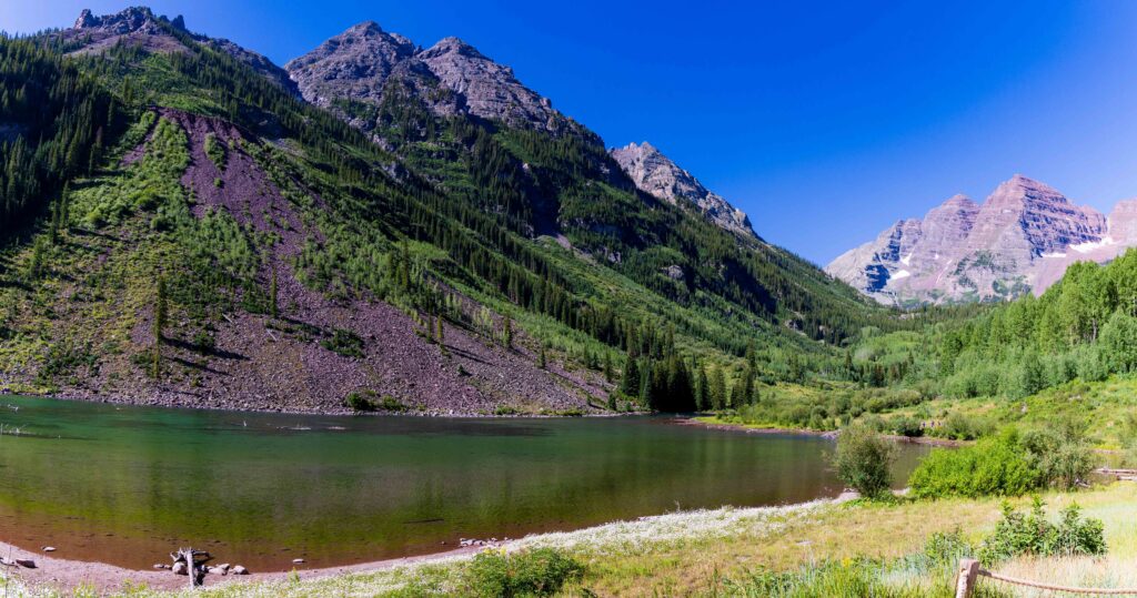 a mountain and lake with blue sky in colorado