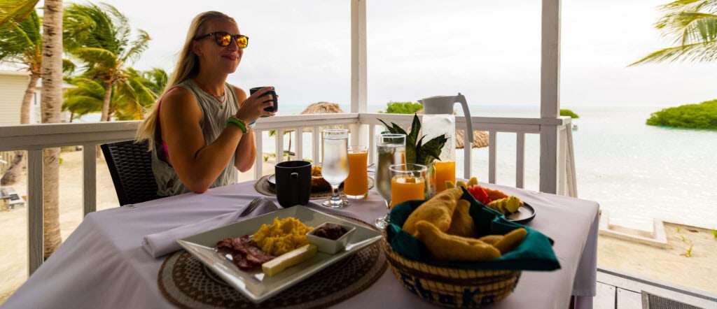 a belize breakfast, a woman holds a cup of coffee