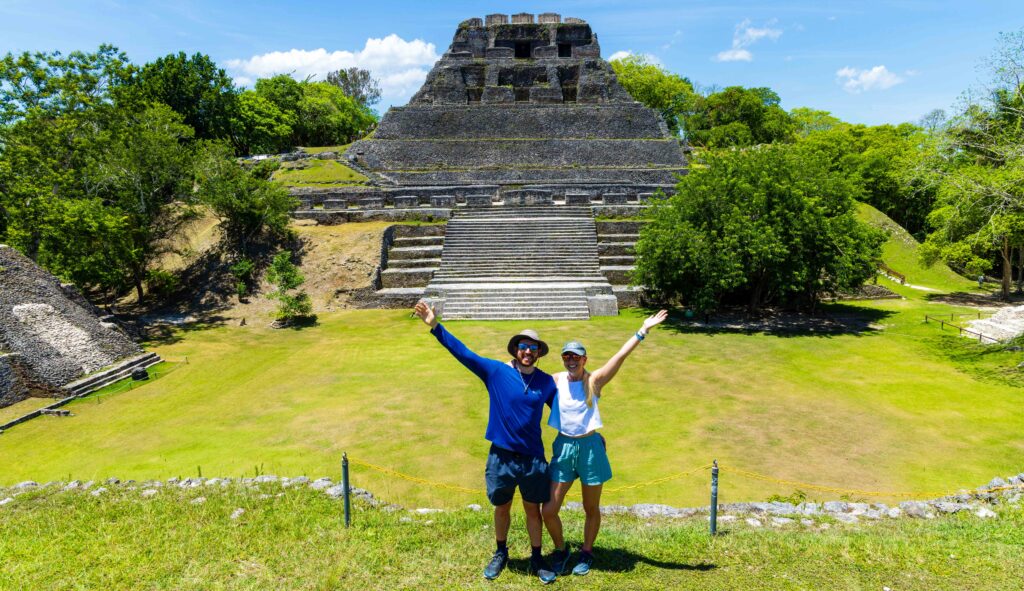 a man and woman take a photo infront of a mayan ruin