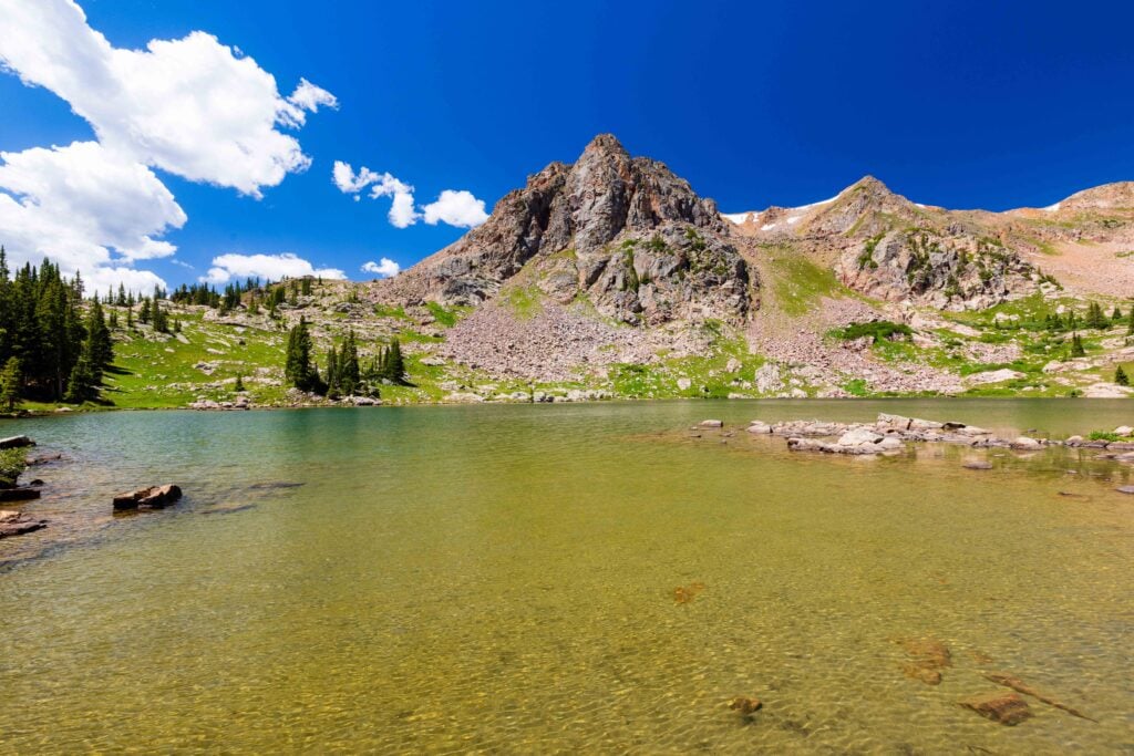 a lake with mountains and clouds