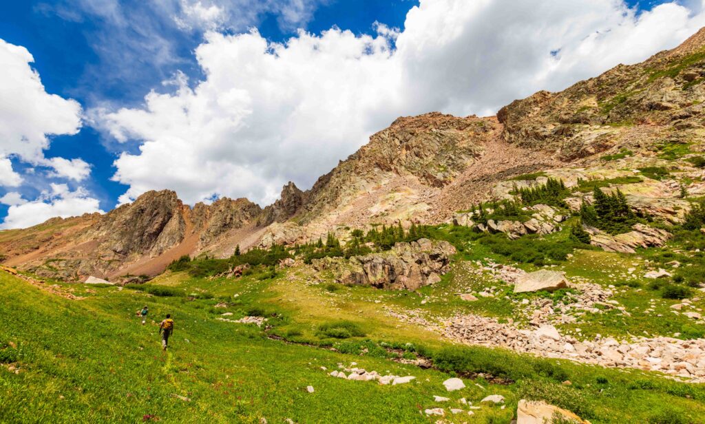 a green and rocky valley with mountains