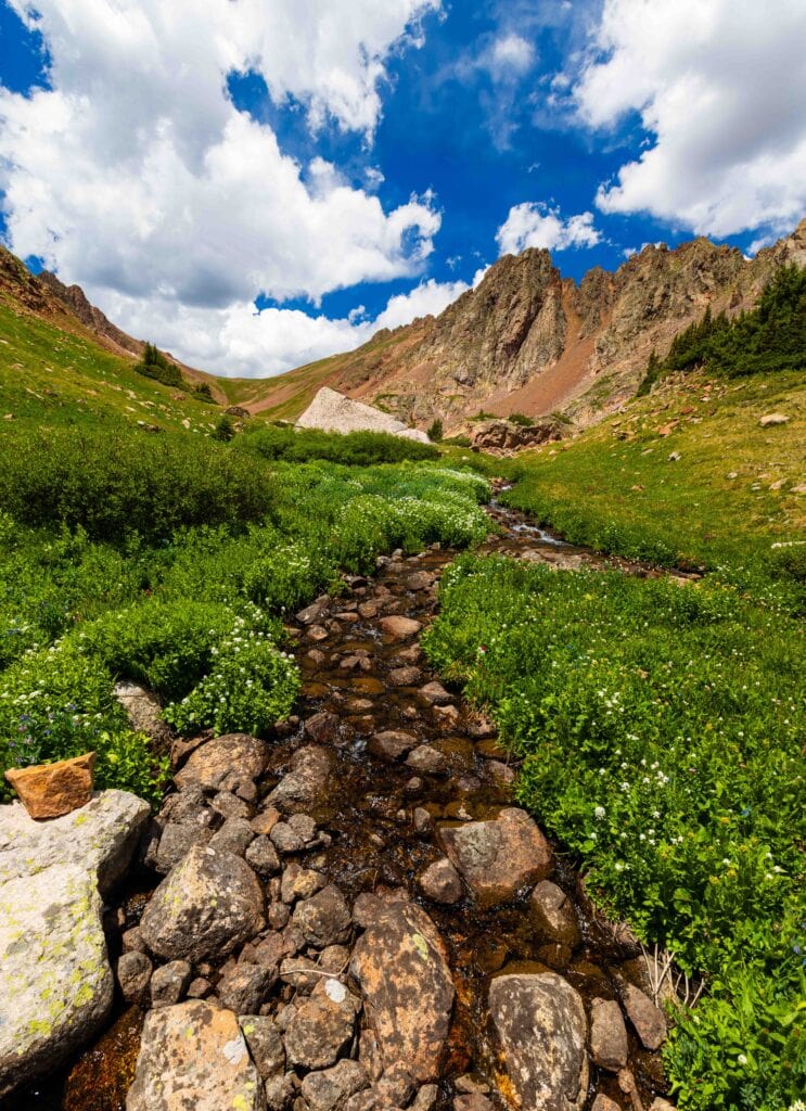 a rocky creek flows through the mountains