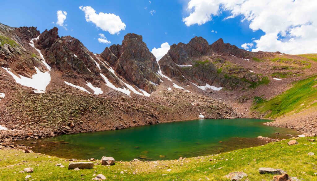snow lake with towering craggy peaks above