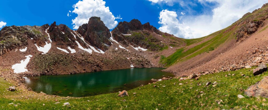 snow lake with towering craggy peaks above