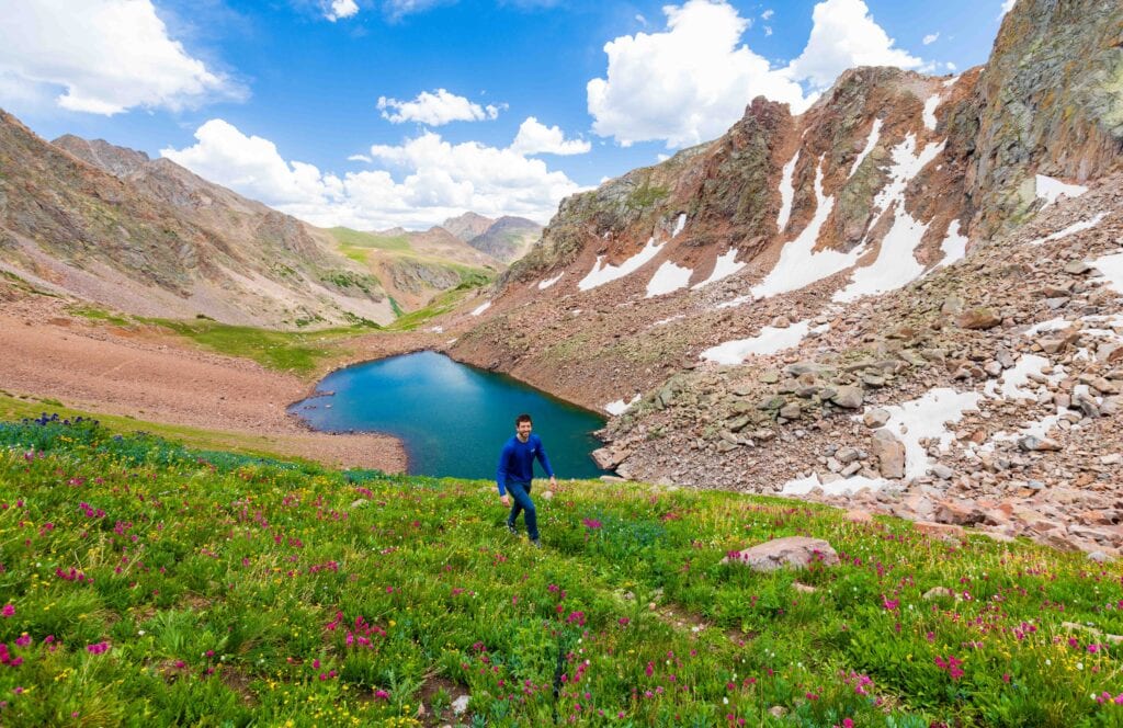hikers walk on a trail above snow lake in the gore range
