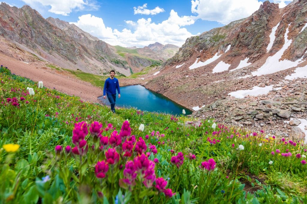 hikers walk on a trail above snow lake in the gore range