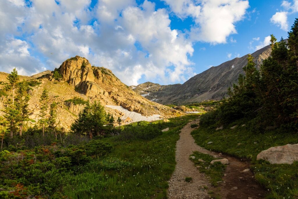 a trail in colorados indian peaks wilderenss with a big mountain on the left hand side