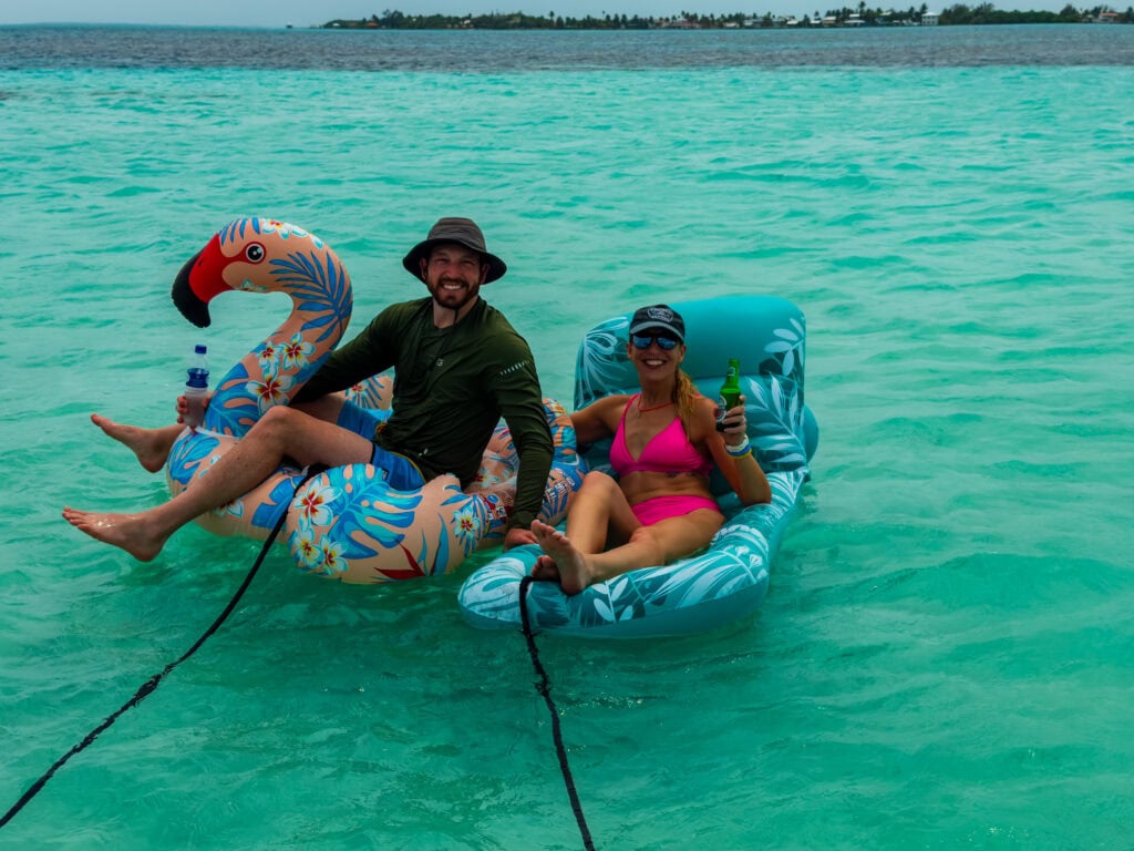 a couple sit on floaties in belize