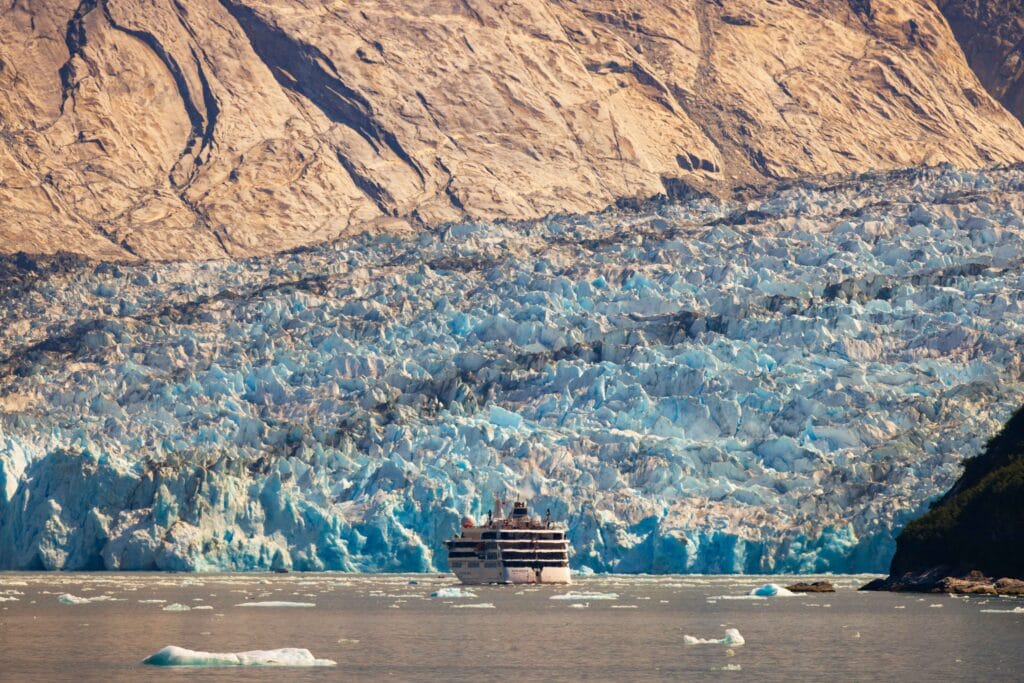 the dawes glacier with a cruise ship in the middle of the frame