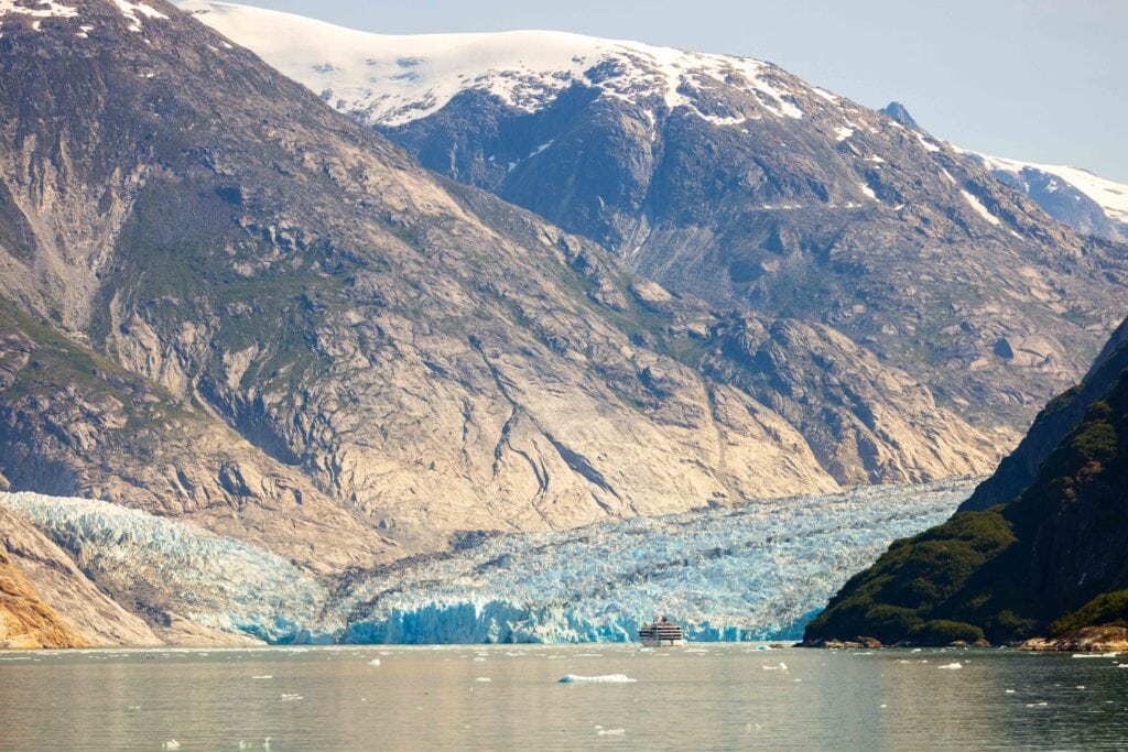 the dawes glacier with a cruise ship in the middle of the frame