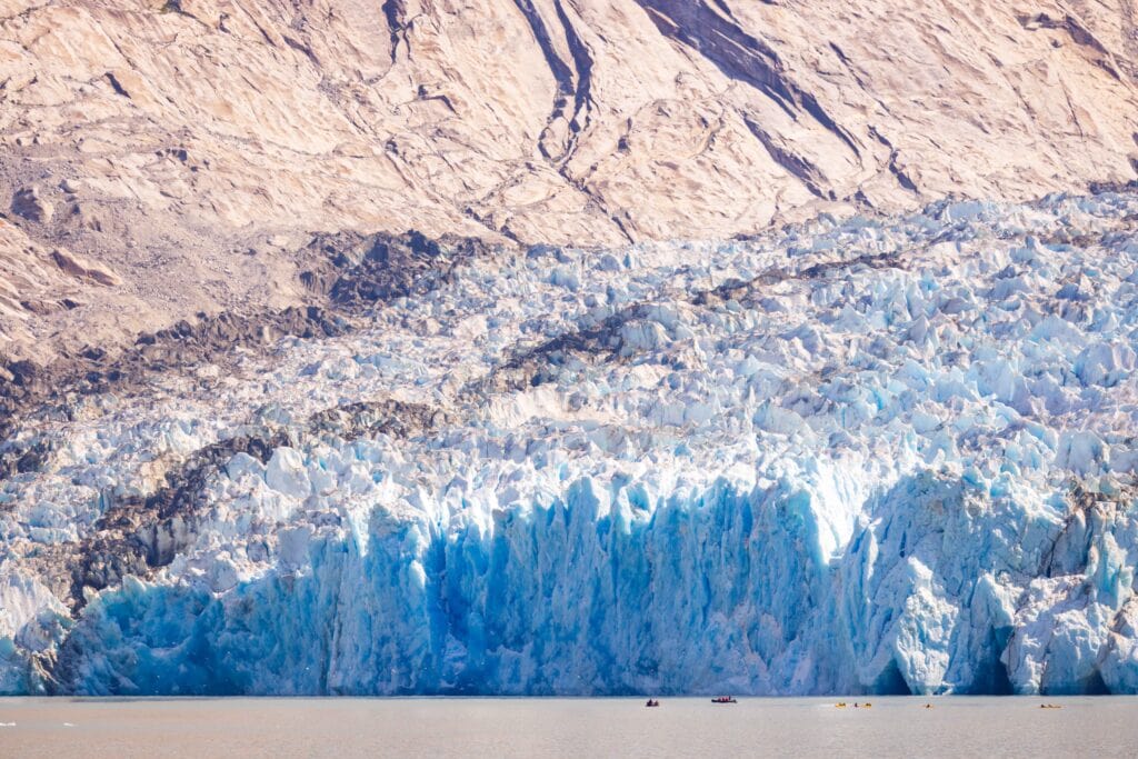 the dawes glacier with tiny kayakers nearby