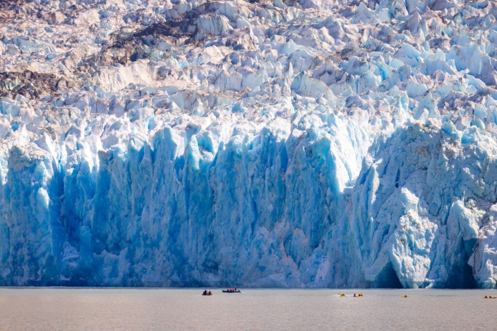 the dawes glacier with tiny kayakers nearby