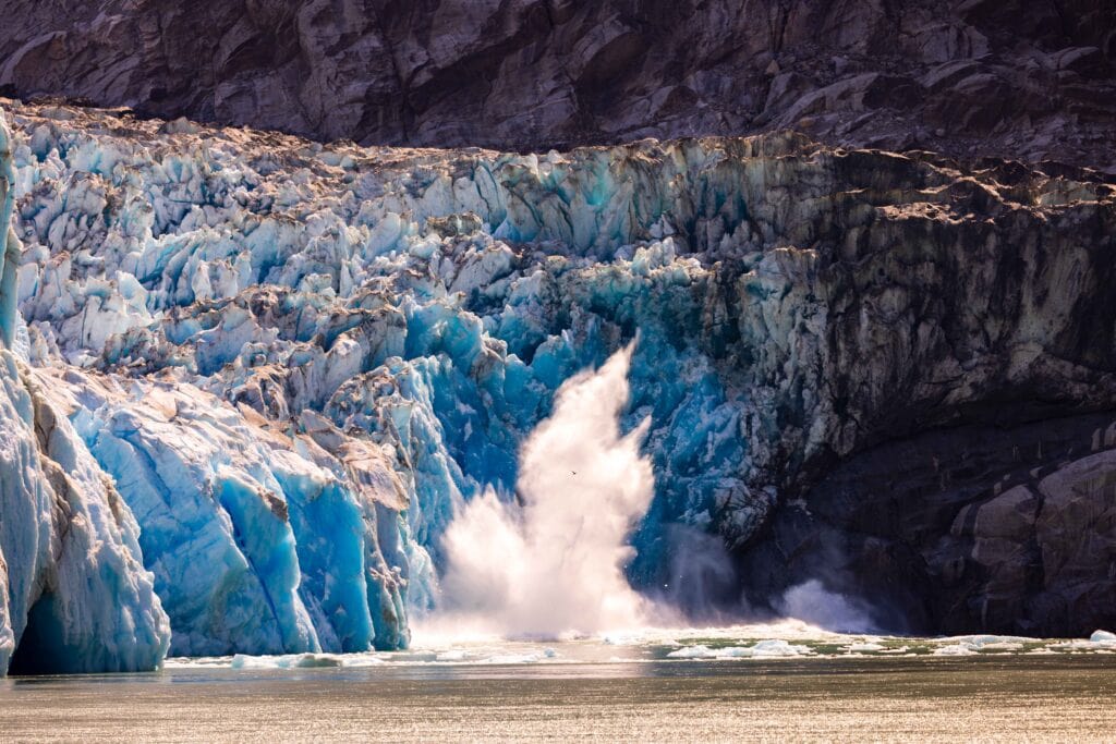 the splash from a piece of the dawes glacier falling into the ocean
