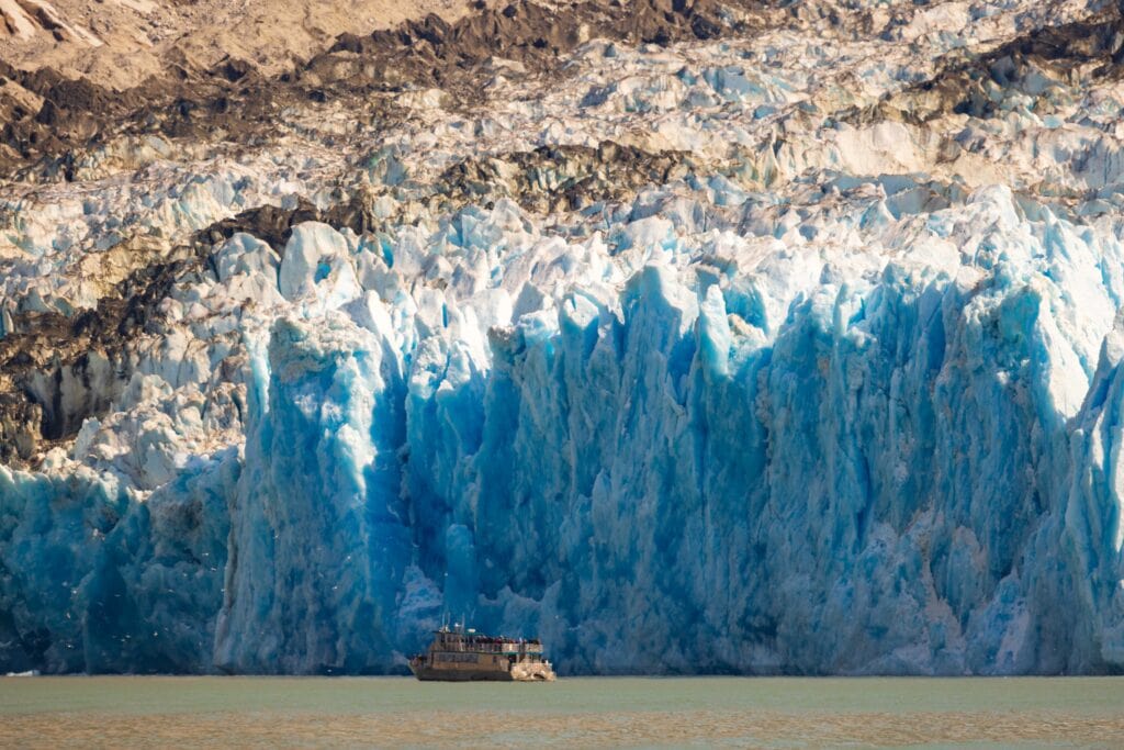 the dawes glacier with a small sightseeing boat nearby