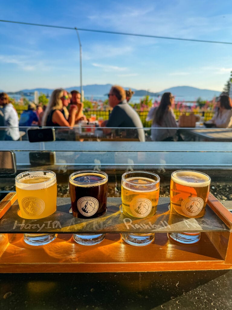 a beer flight with auke bay in the background