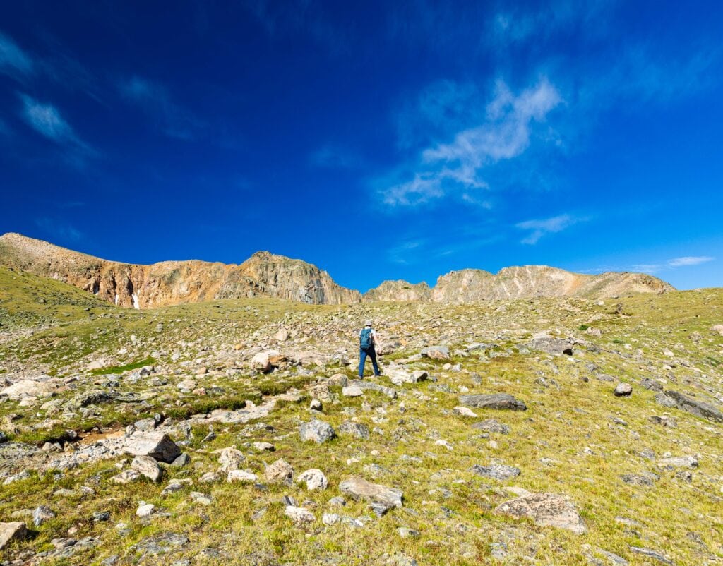 a hiker on the trail with blue sky above