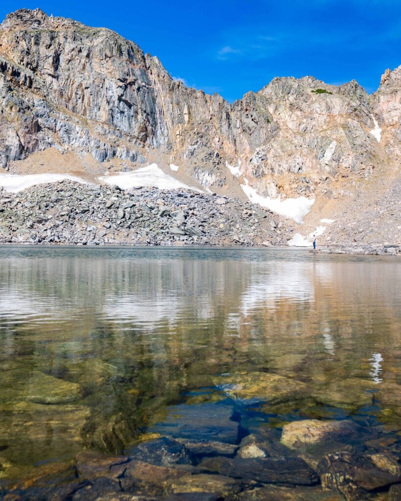rocks at the bottom of lake dorothy with tall peaks in the distance