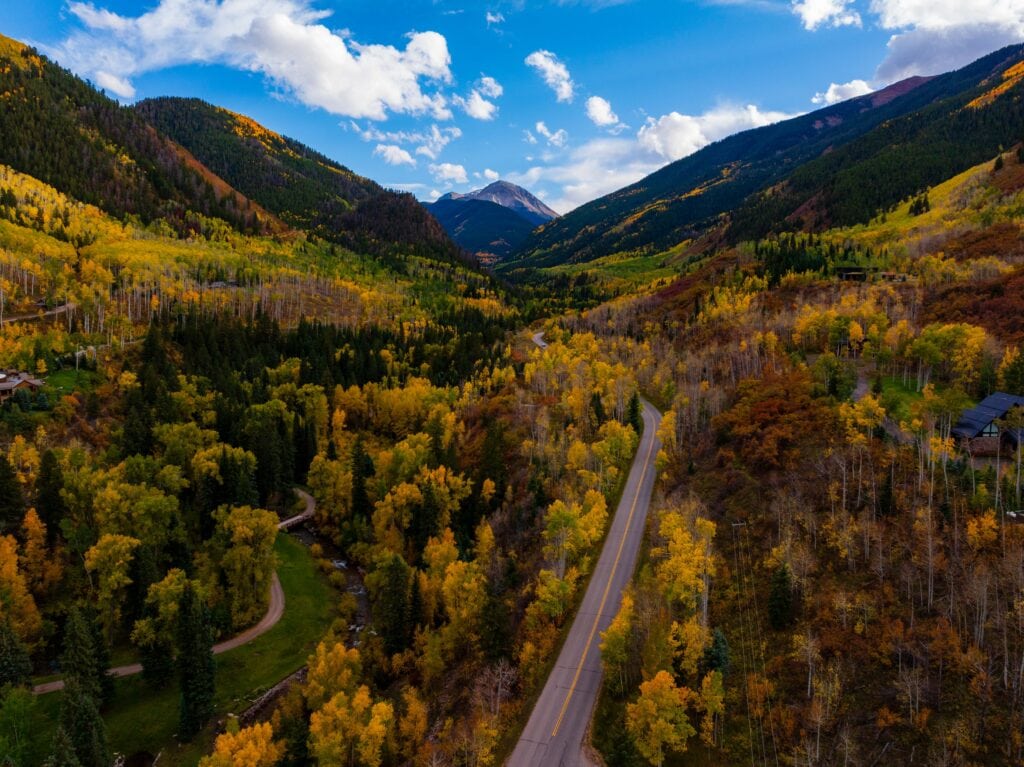 aspen lines slopes in colorado wiht a road going down the middle of the valley