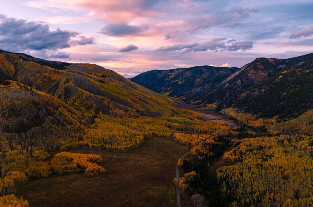 an aerial view of fall colors and mountains near aspen