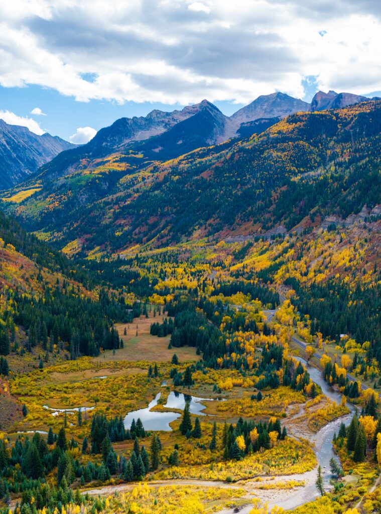 redstone historic distric fall colors lining the slopes with a creek and mountains in view
