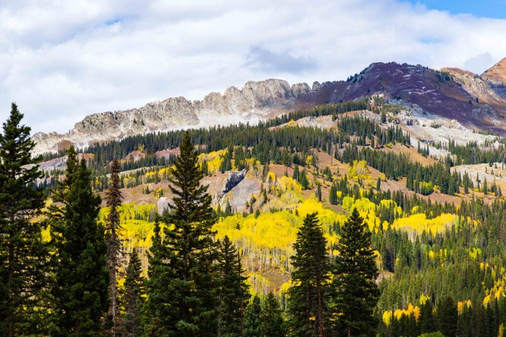 jagged mountains with yellow aspens on its slopes