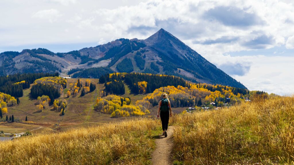 a woman walks on a trail in crested butte colorado
