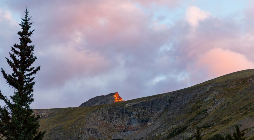 pink clouds at sunrise with light hitting south arapaho peak