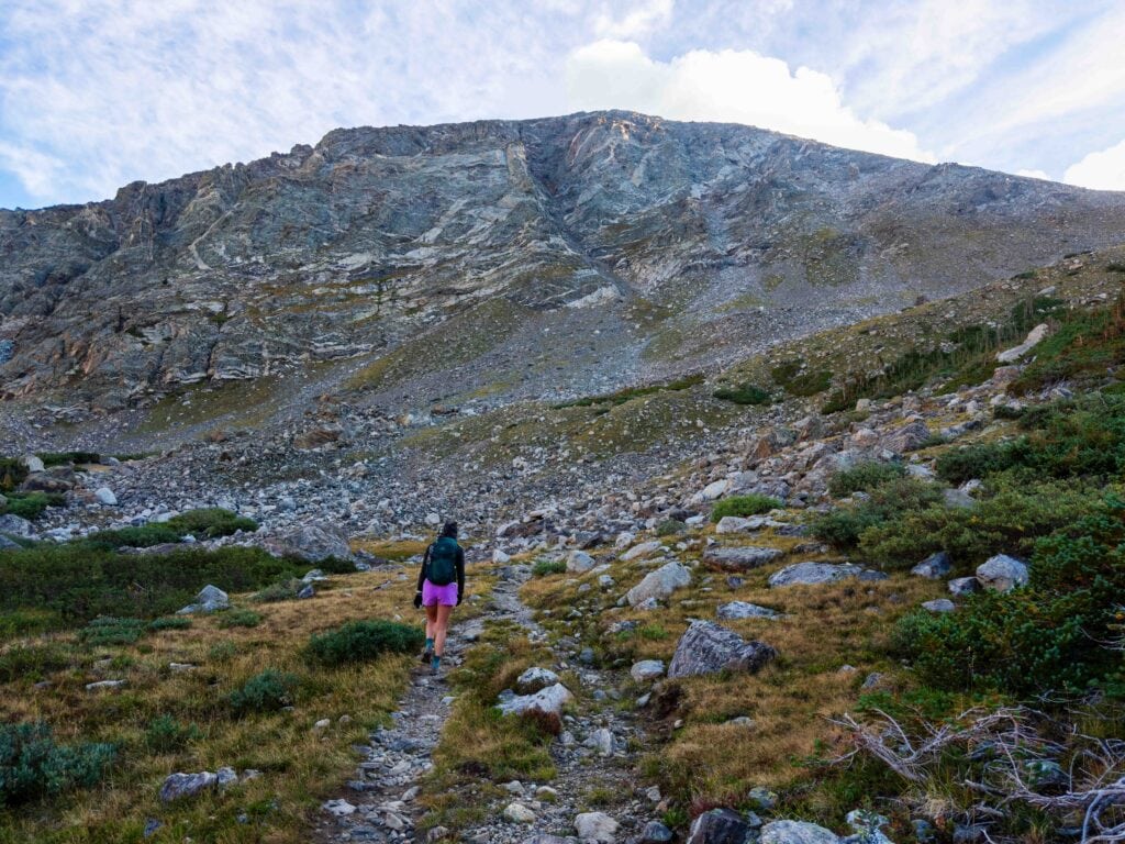 hikers on a trail with south arapaho peak high above