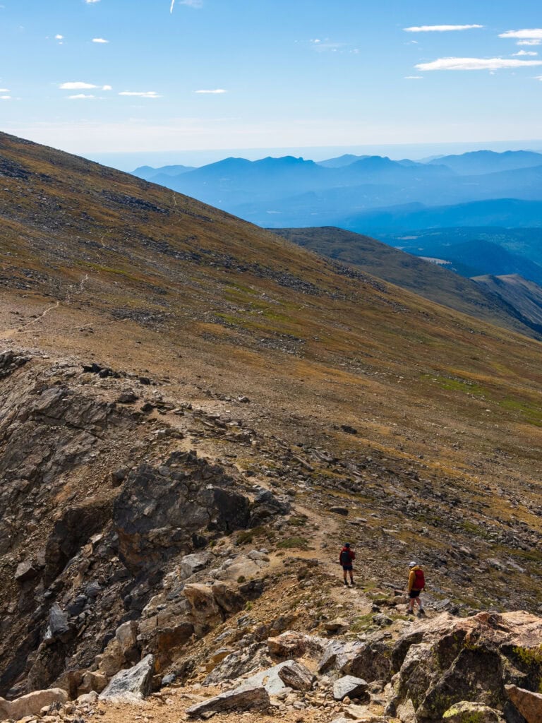 two hikers on the ridgeline below south arapaho peak in colorado