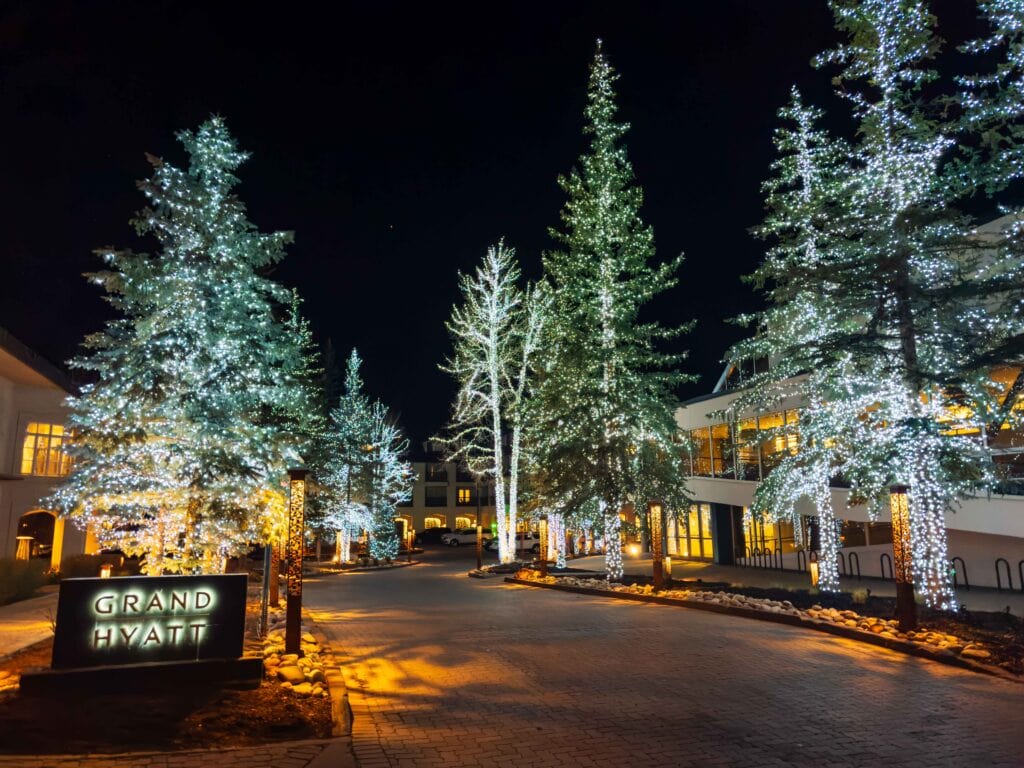the entrance of the grand hyatt in vail with lights on the trees