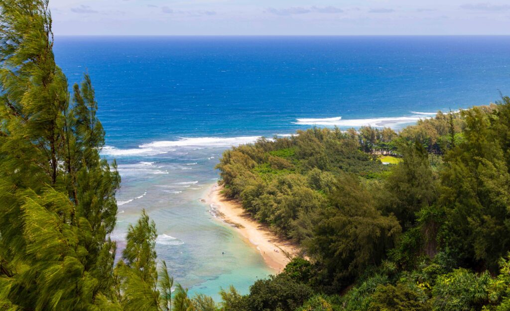 views of Ke'e beach far below while on the hanakapiai beach hike
