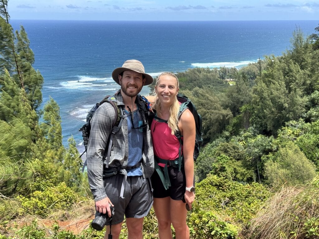 a couple pose for a photo along the Kalalau Trail to Hanakapi'ai Beach