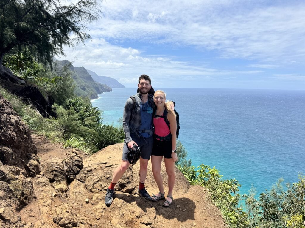 a couple pose for a photo along the Kalalau Trail to Hanakapi'ai Beach